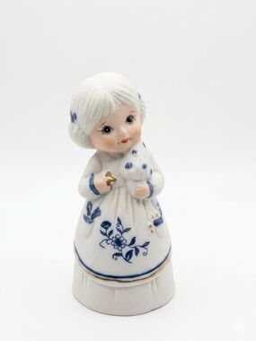 White Ceramic Girl Figurine with Blue Floral Detail and Gold Accent